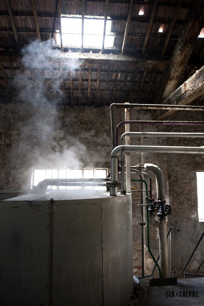 Vaření marseillského mýdla v kotli továrny s odpařující se párou
